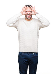 Fototapeta premium Young handsome man wearing glasses over isolated background doing ok gesture like binoculars sticking tongue out, eyes looking through fingers. Crazy expression.