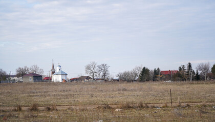 the church of a village viewed from the agricultural area. rural landscape.