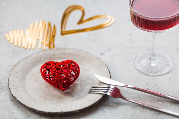 The banner. Table setting. A stylish ceramic plate, a glass of red wine, a fork and gold, red...
