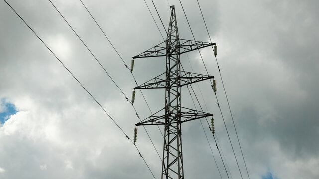 Power line pylon against the background of the dark cloudy sky