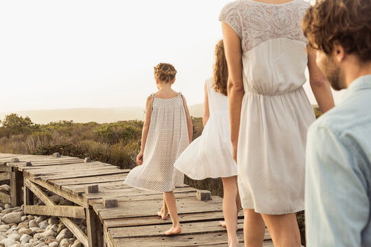family walking on a board walk at a beach house