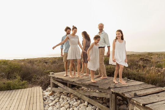 family walking on a board walk at a beach house