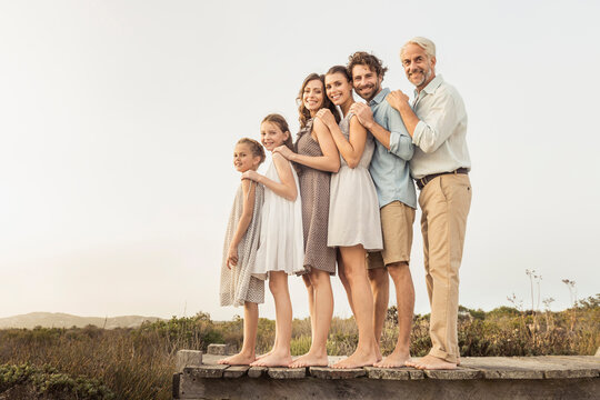 Family portrait outside on a boardwalk at a beach house
