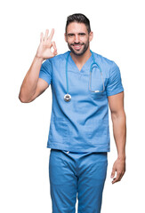 Handsome young doctor surgeon man over isolated background smiling positive doing ok sign with hand and fingers. Successful expression.