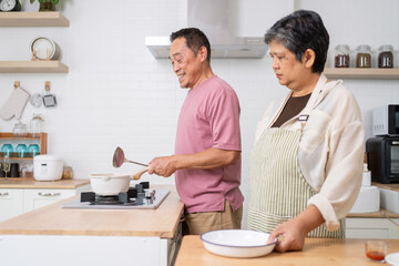 Mature asian Couples enjoy to cooking meal together in kitchen.