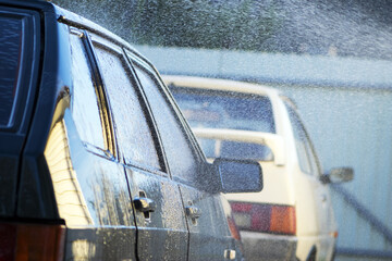 water from a hose from a spray bottle washes the car. Car washes use high pressure water sprays,...