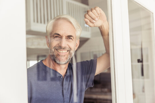 best ager Mann schaut gl&uuml;cklich aus dem Fenster, Kapstadt, S&uuml;dafrika