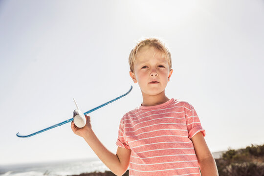 Young boy playing with and flying his model airplane