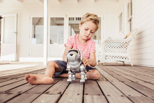 young boy playing with his little robot dog