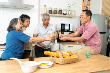 Group of Happy Asian senior drinking wine to celebrate while dining together