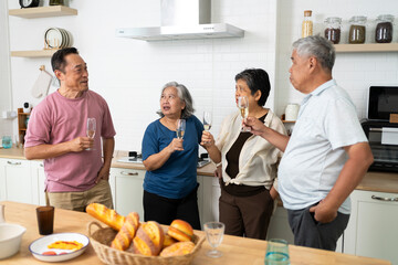 Group of Happy Asian senior drinking wine to celebrate while dining together
