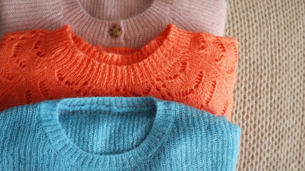 Three warm sweaters close-up. Women's stylish autumn or winter clothes. Cozy Winter look. Flat lay, top view.