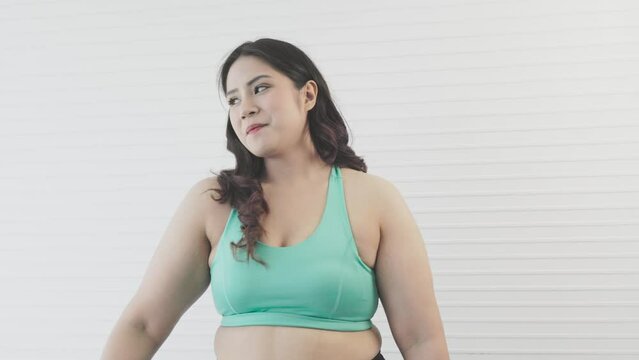 chubby asian woman stretches to warm up before exercising