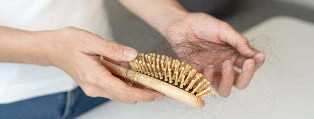 Close-up young woman brushing her hair and have many hair loss on the comb