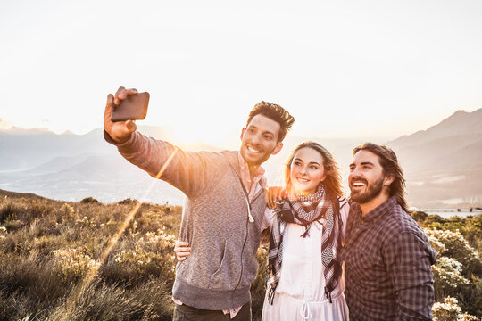 Group of friends taking a selfie in the mountains at sunset