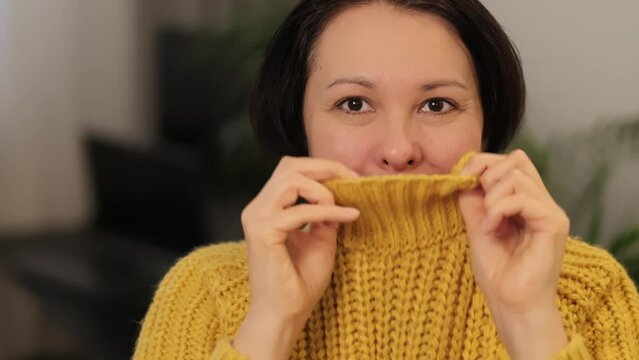 The woman's cheerful demeanor, accentuated by the bright knitwear, captures the essence of finding happiness in the little things.