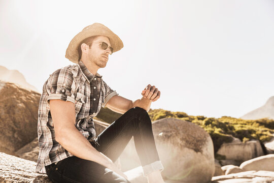 Guy hanging out on the beach with cowboy hat