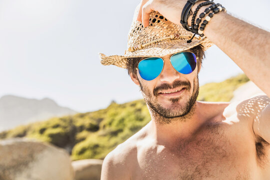 Guy with Boho style hanging out and having fun on the beach.