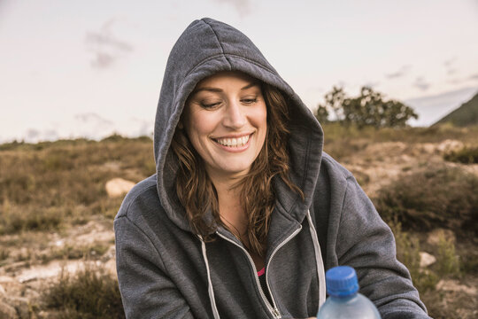 Beautiful overweight woman exercising on a mountain at sunset