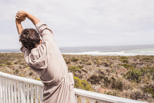 Man enjoying morning coffee in a bath robe at a beach house