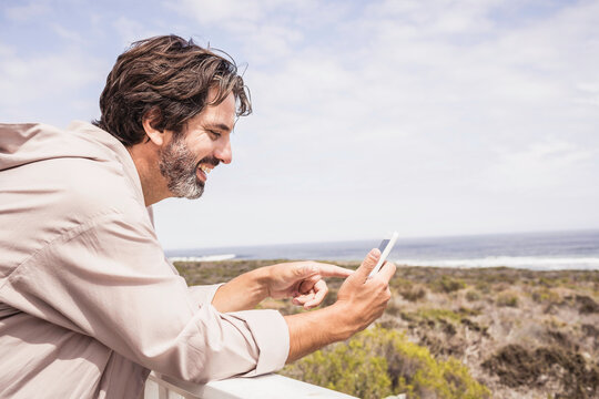 Man enjoying morning coffee in a bath robe at a beach house