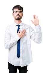 Young handsome business man wearing glasses over isolated background Swearing with hand on chest...