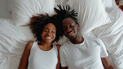 Young calm african loving couple girl guy in t-shirts lying on bed with white sheet pillow blanket indoors in bedroom at home, spending time in room. Rest relax good mood quarantine lifestyle concept - obrazy, fototapety, plakaty