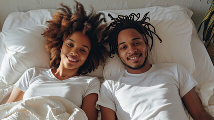 Young calm african loving couple girl guy in t-shirts lying on bed with white sheet pillow blanket indoors in bedroom at home, spending time in room. Rest relax good mood quarantine lifestyle concept - obrazy, fototapety, plakaty