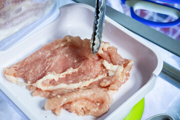 Raw marinated pork for shabu hotpot.