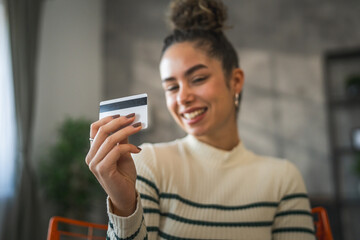 Fototapeta premium young woman caucasian female hold credit card online shopping at home