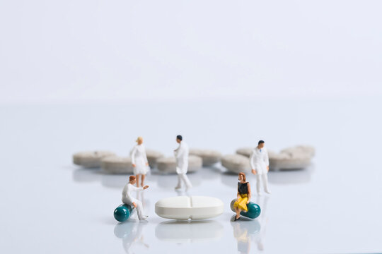 Doctor talking to a patient, miniature figures scene, white background
​
