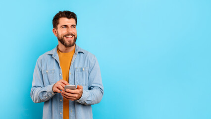man texting on mobile phone near free space, blue background