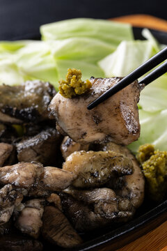 柚子胡椒をつけて地鶏を食べる