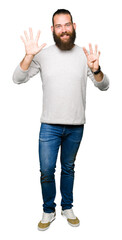 Young blond man wearing casual sweater showing and pointing up with fingers number nine while smiling confident and happy.