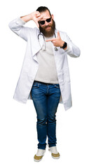 Young blond doctor man with beard wearing sunglasses smiling making frame with hands and fingers with happy face. Creativity and photography concept.