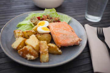 Steamed salmon fillet with potato wedges, guacamole homemade and quail egg