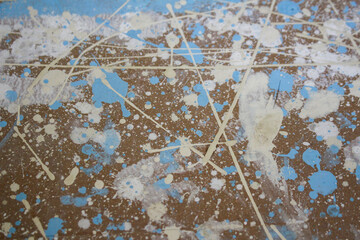 Abstract spots, drops of yellow blue white paint on a brown wooden surface