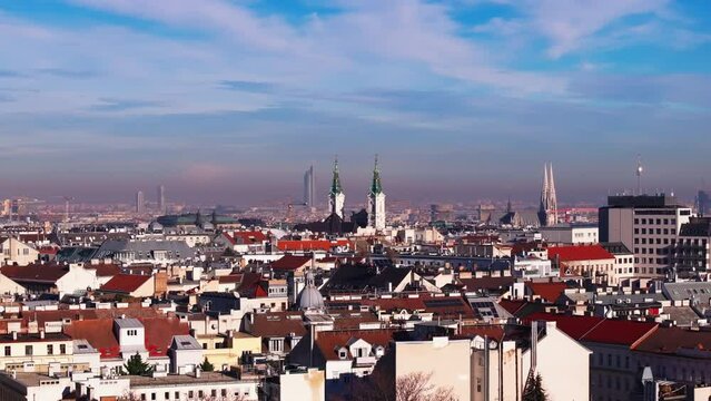 Church towers and modern high rise buildings in background exceeding surrounding buildings in urban borough. Vienna, Austria