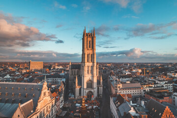 Watching the sunset over Ghent from the historic tower in the city centre. Romantic colours in the sky. Red light illuminating Ghent, Flanders region, Belgium - obrazy, fototapety, plakaty