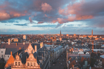 Fototapeta na wymiar Watching the sunset over Ghent from the historic tower in the city centre. Romantic colours in the sky. Red light illuminating Ghent, Flanders region, Belgium
