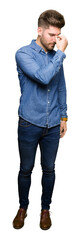Young handsome blond man wearing casual denim shirt tired rubbing nose and eyes feeling fatigue and...