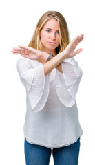 Beautiful young elegant woman over isolated background Rejection expression crossing arms doing negative sign, angry face