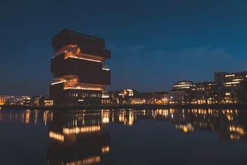  Art museum building on the riverbank in the centre of Antwerp lit up at night. Modern part of the city. Belgian architecture © Fauren
