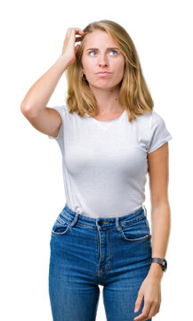 Beautiful young woman wearing casual white t-shirt over isolated background confuse and wonder about question. Uncertain with doubt, thinking with hand on head. Pensive concept.