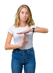 Beautiful young woman wearing casual white t-shirt over isolated background Doing time out gesture...