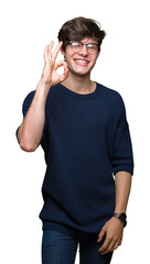 Young handsome man wearing glasses over isolated background smiling positive doing ok sign with hand and fingers. Successful expression.