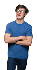 Fototapeta premium Young handsome man wearing glasses over isolated background happy face smiling with crossed arms looking at the camera. Positive person.