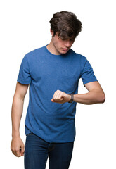 Young handsome man wearing blue t-shirt over isolated background Checking the time on wrist watch, relaxed and confident