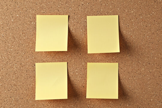 Four yellow sticky notes on cork board