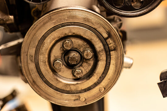 Photo focusing on the intricate pulleys of a car engine